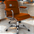 Cadeira Original Eames Diretor com Rodinhas Cromadas e Anti Risco Linha Capa em Madeira Escura Caramelo - Imagem 2