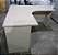 Mesa de Escritório em L Usada 1,40m x 1,40m Tampo 25mm Cor Ovo Base Pé Painel - Imagem 1