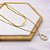 COLAR DUPLO AÇO INOXIDÁVEL 45CM FITA COM PINGENTE LACRE PEROLADO - DOURADO - Imagem 1