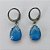 BRINCO EM AÇO INOXIDÁVEL - BRINCO ARGOLINHA DE PRESSÃO COM PINGENTE EM RESINA AZUL COM BRILHOS 3X7MM - COMPOSIÇÃO: AÇO INOXIDÁVEL - (AÇO1820) ACBR000326 - Imagem 1