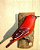 Tiê Sangue - Pássaro esculpido em madeira apoiado em um puleiro de casca de árvore - Imagem 1