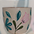 Vaso de cerâmica vermelha com flores e folhas - Imagem 1