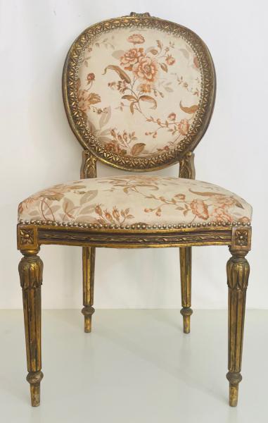 LUIS XVI - Sofisticada cadeira com estrutura em madeira nobre entalhada ao estilo Luis XVI com resquícios de antiga douração e estofamento em tecido floral. Manchas do tempo. Mede 94cm.