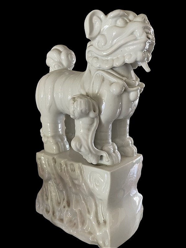 Escultura em porcelana oriental, blanc de chine, branca esmaltada , representado cão de fó , símbolo de proteção , com base trabalhada, mede 34x18x32 cm largura, peso 6 kg