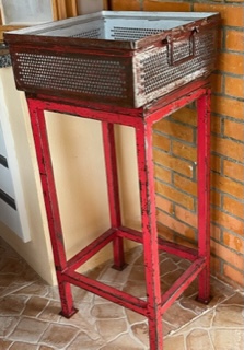 Diferente peça em ferro montada com uma caixa em chapa de ferro com duas alças e uma tampa em madeira, ferro com policromia vermelha