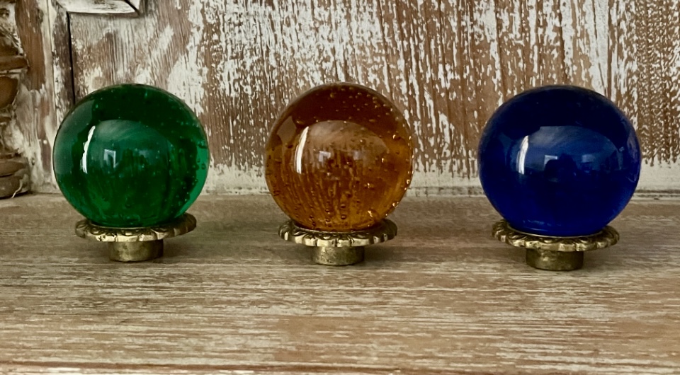 Três bolas de vidro colorido com base em madeira com pátina dourada, mede 7x6 cm peças decorativas