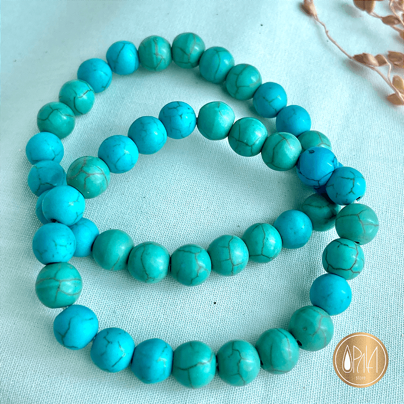 Pulseira Howlita Turqueza 8mm no pulso em fundo neutro, esferas brancas e azuis de cristal natural, Opala Store