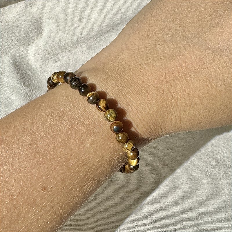 Pulseira de Olho de Tigre Natural Opala Store em detalhe de construção com fio de silicone duplo e esferas 6mm