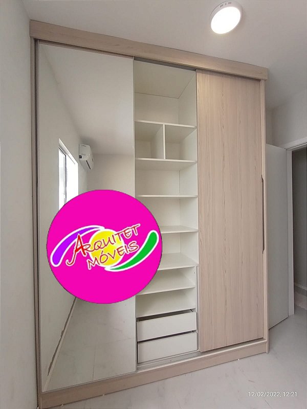 Guarda roupa planejado em mdf branco tx com três portas de correr, sendo uma em espelho e duas na cor cipres baikal