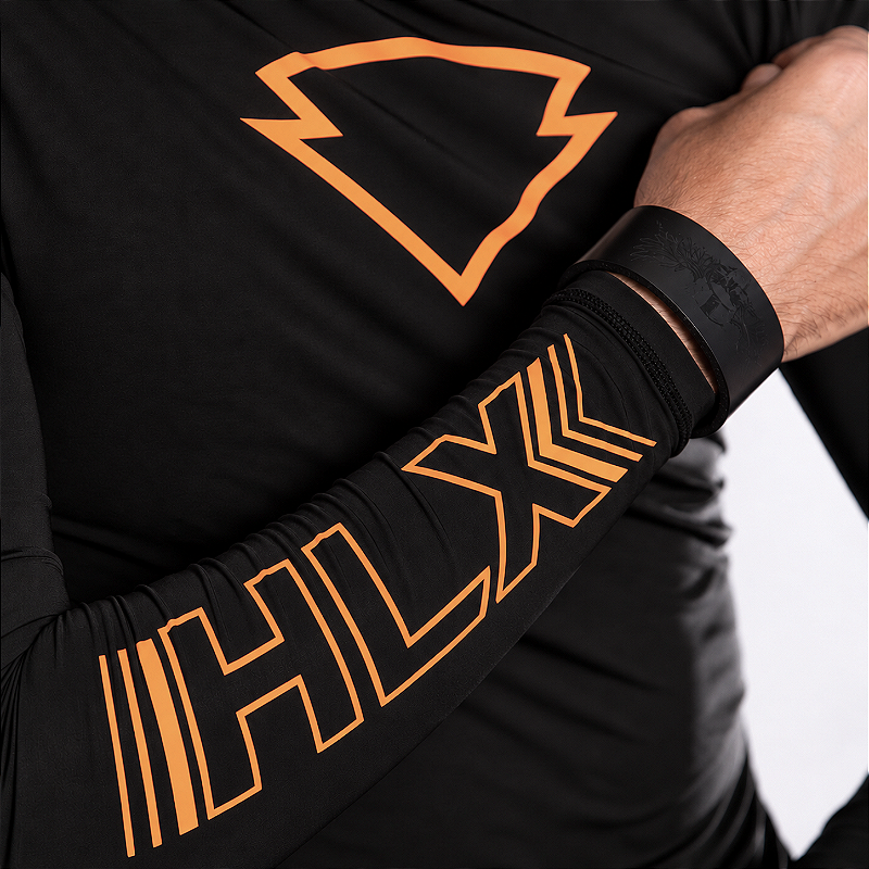 Detalhe da manga com marca HLX laranja na segunda pele preta e laranja masculina