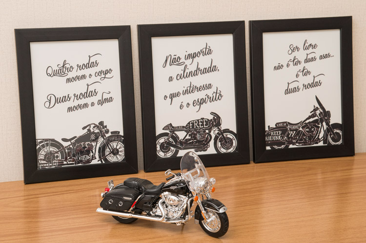 Três quadros com frases de moto e uma miniatura Harley-Davidson Road King sobre o aparador