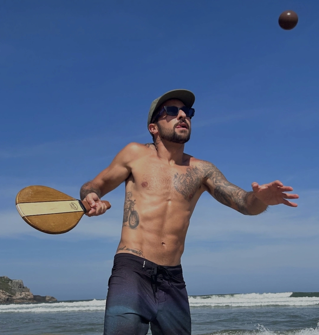 Modelo jogando frescobol na praia
