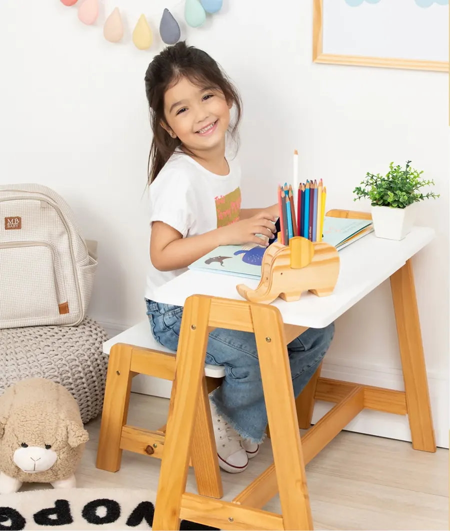 Menina desenhando na mesinha de madeira Cola e Decora