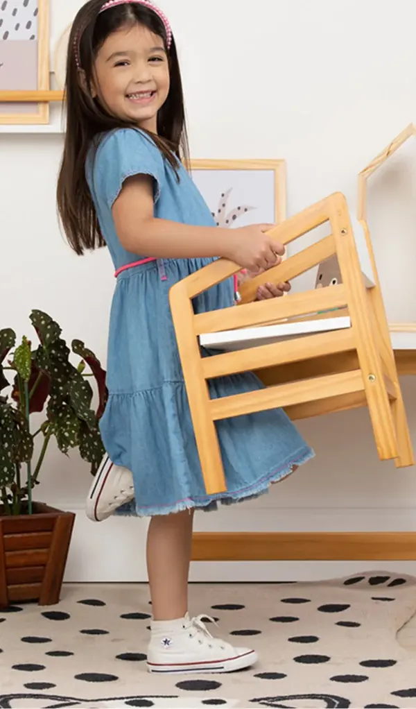 Menina carregando a cadeirinha de madeira