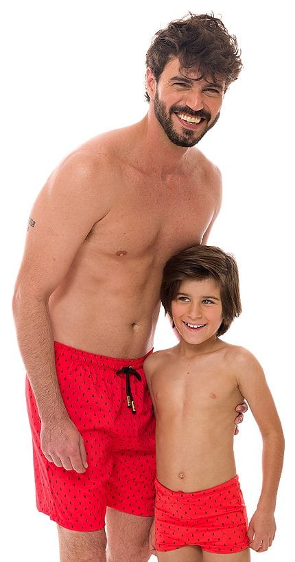 Pai e filho com shorts e sunga da mesma estampa